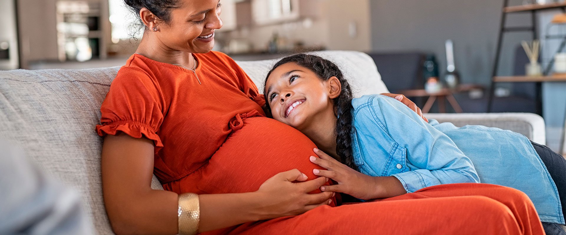 mulher gravida com criança apoiada na barriga